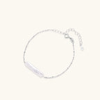 Minimalist bracelet with iridescent baroque pearl on rhodium-plated sterling silver chain against cream background